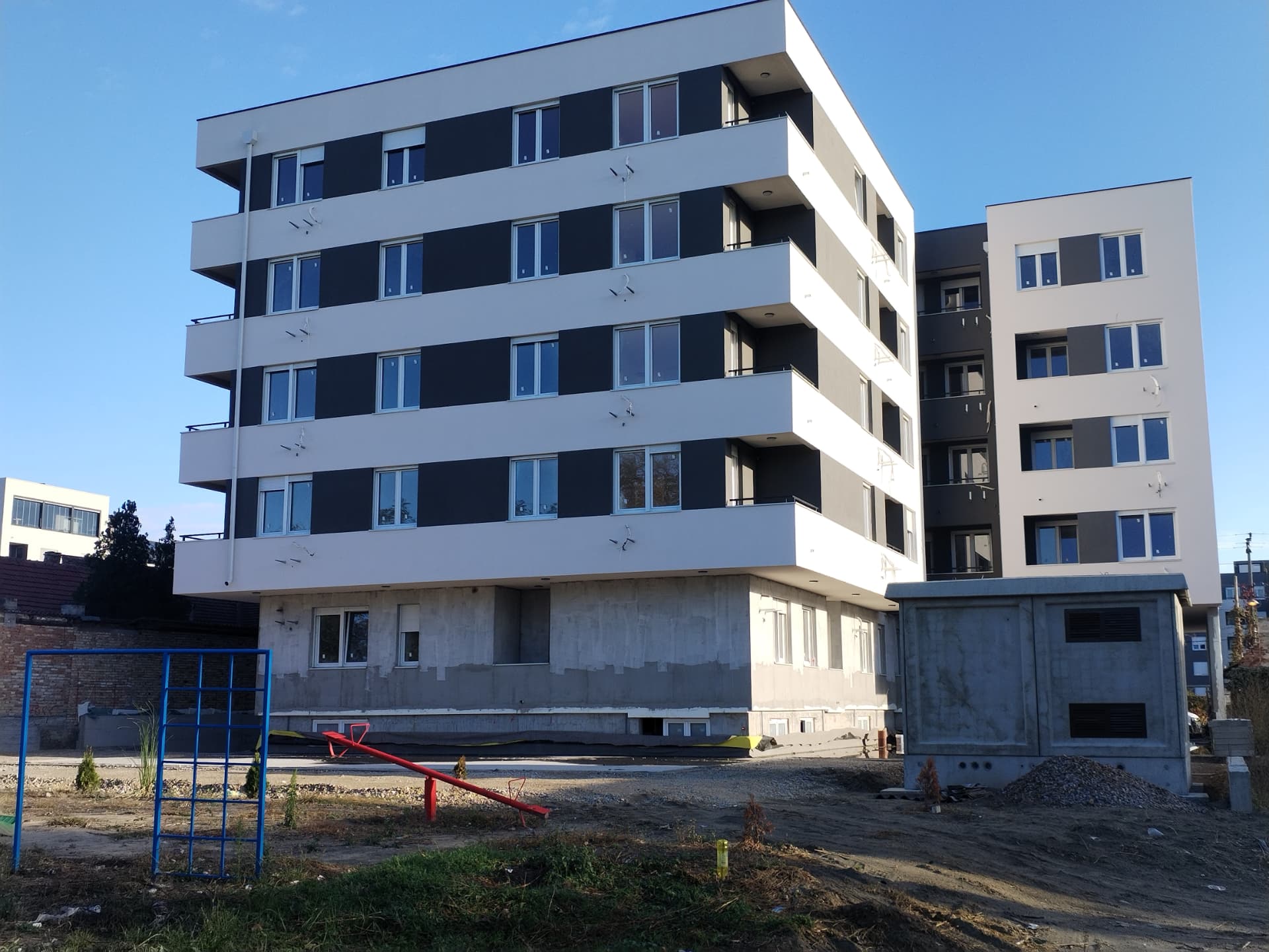 Rear façade of a multi-unit residential development in Serbia with continuous terraces