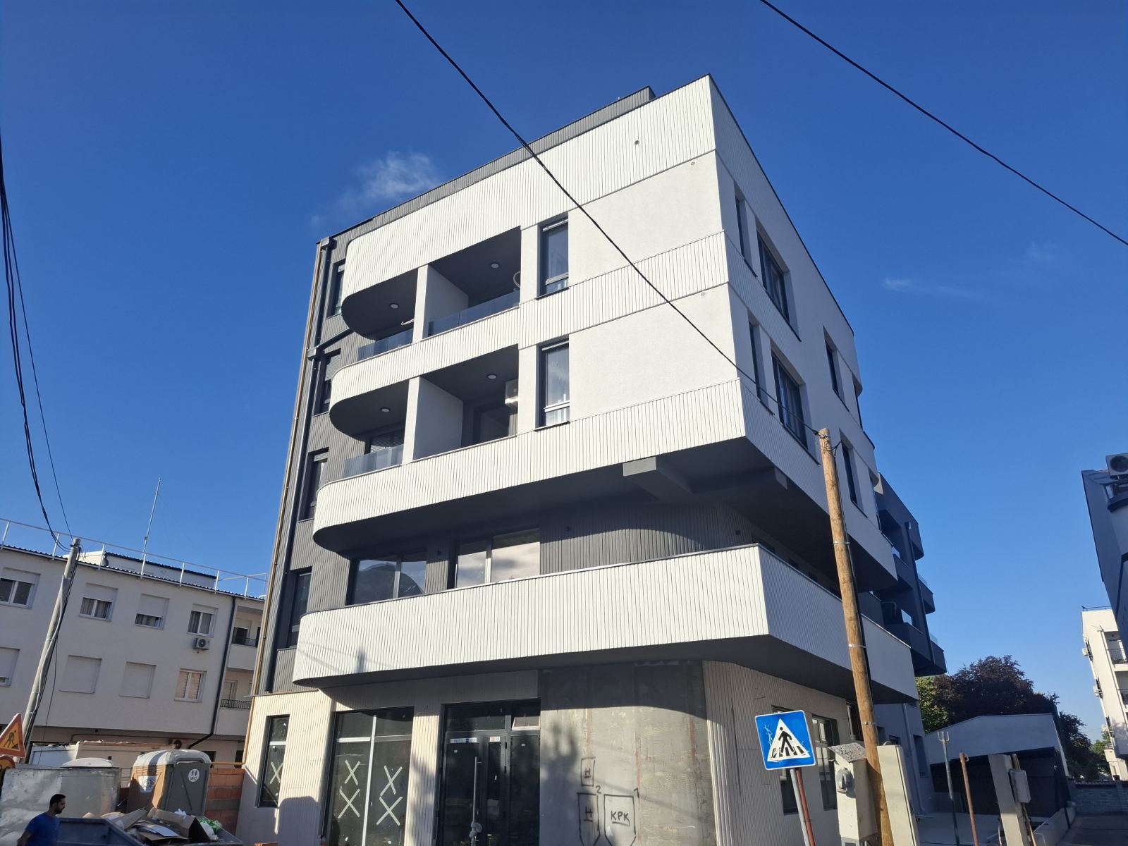 Corner view of the Vršačka 36 residential building in Novi Sad with recessed balconies and ground-floor commercial space