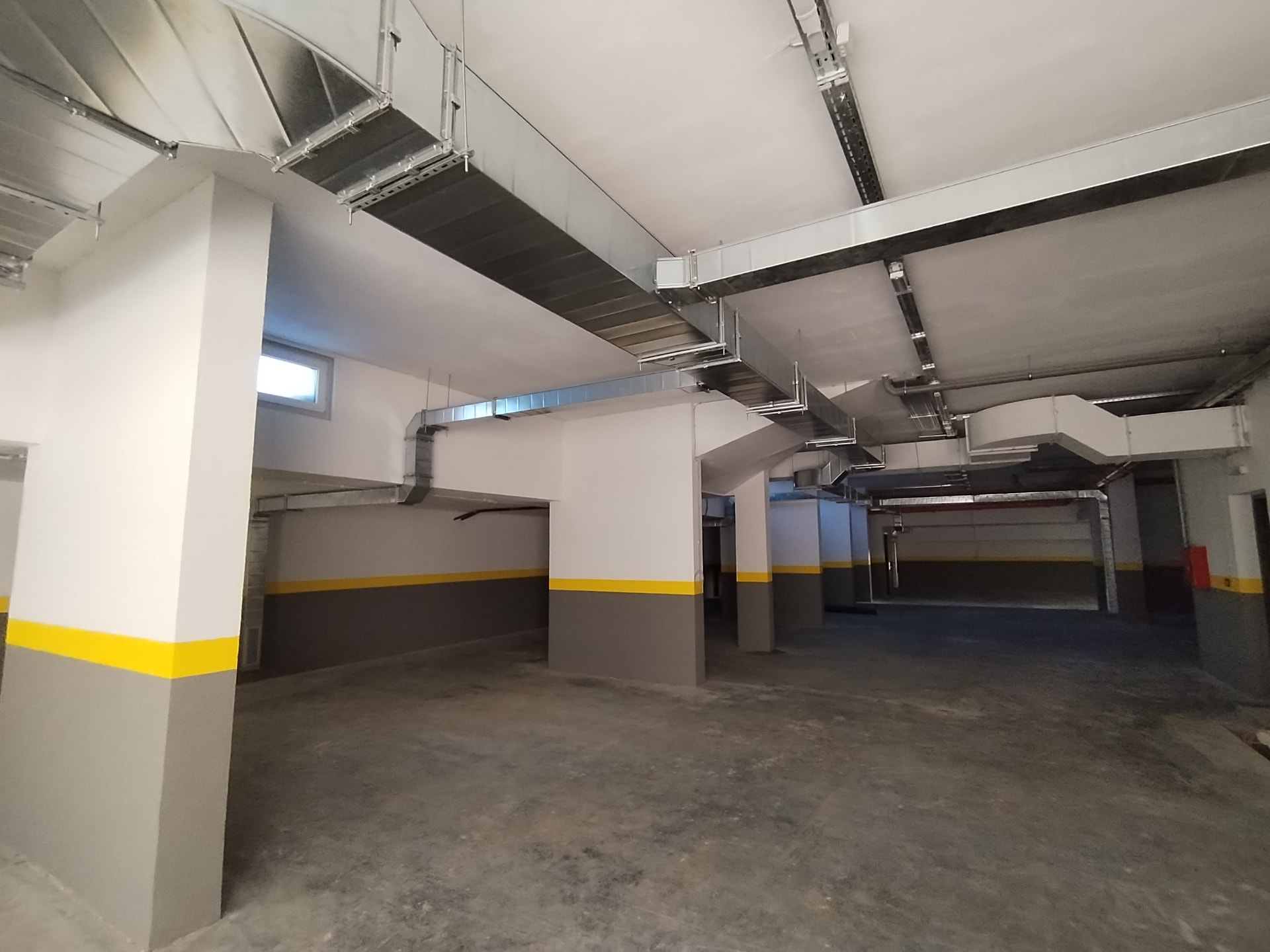 Completed underground parking garage of a residential development in Serbia with ventilation ductwork