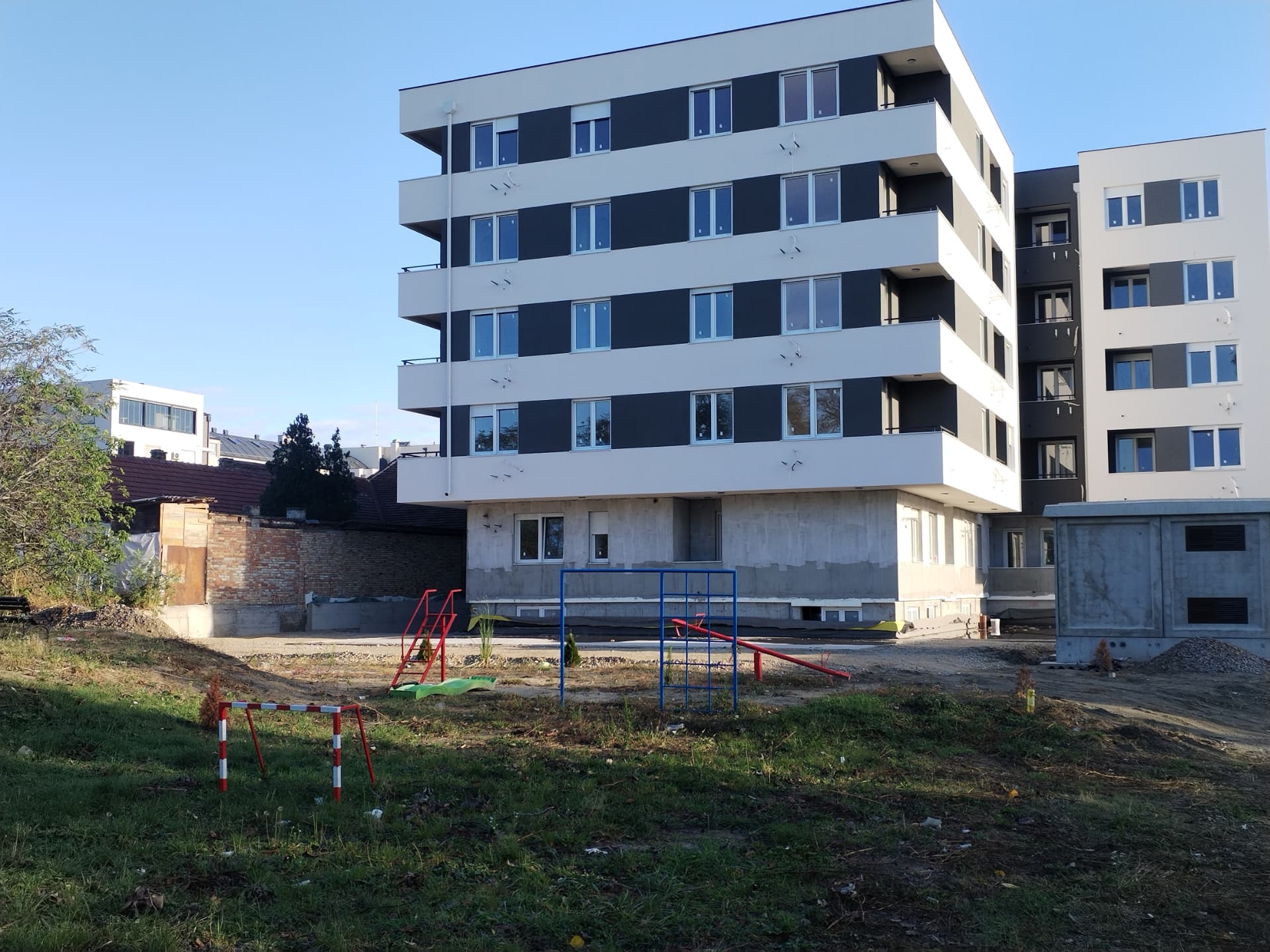 Rear elevation of a residential development in Serbia with a children's play area in the courtyard